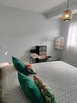 a large bed with a green headboard and two pillows at Piso en el centro de Viveiro in Viveiro