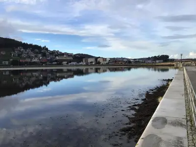 a view of a beach with a boat in the water at Piso en el centro de Viveiro in Viveiro