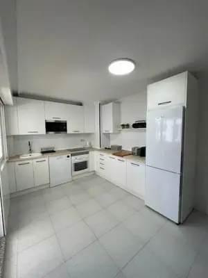 a kitchen with white cabinets and a white refrigerator at Covas Home in Viveiro