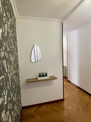 a hallway with a white wall with a shelf and a plant at Covas Home in Viveiro