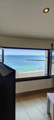 a view of the beach from a room with a large window at BURELA Mariña PLAYA in Burela de Cabo