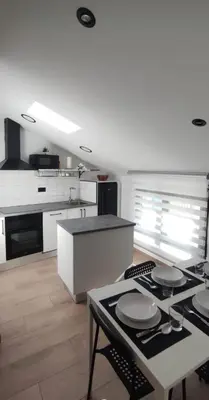 a kitchen with white cabinets and a table with plates on it at BURELA Mariña PLAYA in Burela de Cabo
