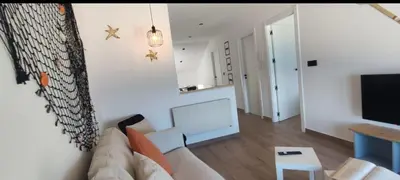 a living room with a couch and a tv at BURELA Mariña PLAYA in Burela de Cabo