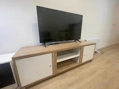 a flat screen tv sitting on top of a wooden entertainment center at Céntrico apartamento muralla 2 in Lugo