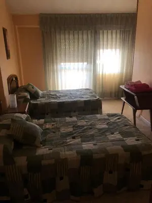 a hotel room with two beds and a window at Hostal Pensión LA TORRE in Fabero
