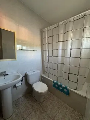 a bathroom with a white toilet and a sink at Hostal Pensión LA TORRE in Fabero