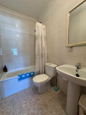 a bathroom with a toilet and a sink and a tub at Hostal Pensión LA TORRE in Fabero