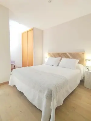 a white bedroom with a large white bed at Viveiro Centro con parking in Viveiro