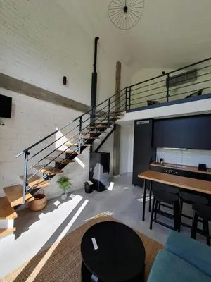 a living room with a staircase and a table at Apartamentos Islas Pantorgas in Tapia de Casariego