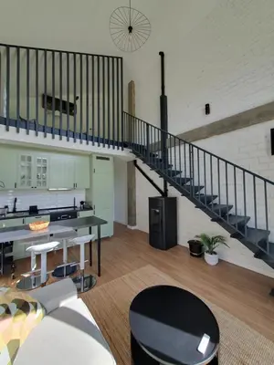a living room with a staircase in a loft at Apartamentos Islas Pantorgas in Tapia de Casariego