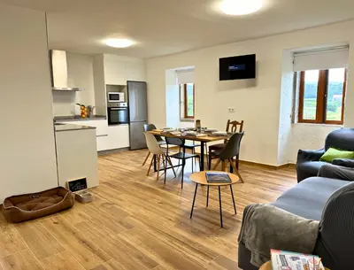 a kitchen and living room with a table and chairs at Casa BastiAna in Carracedo