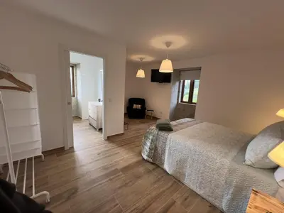 a bedroom with a bed and a table in it at Casa BastiAna in Carracedo
