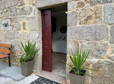 a couch and a chair under a tree in a yard at Casa BastiAna in Carracedo
