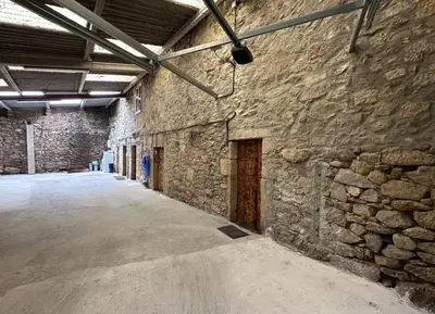 a large stone building with a stone wall at Casa BastiAna in Carracedo