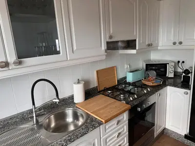 a kitchen with a sink and a stove top oven at Piso a pie de playa in Burela de Cabo
