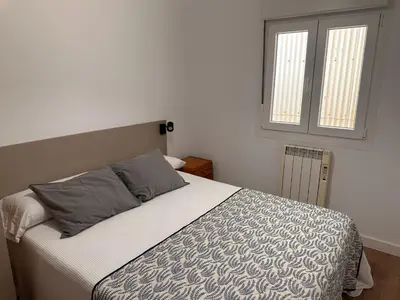 a bedroom with a bed and a window at Piso a pie de playa in Burela de Cabo