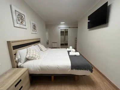 a bedroom with a bed with a television on the wall at Neypa Liberdade in Sarria