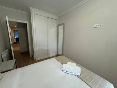 a white bedroom with a bed with a towel on it at Neypa Liberdade in Sarria