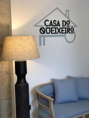 a lamp next to a couch with a sign on the wall at CASA DO QUEIXEIRO in Castroverde