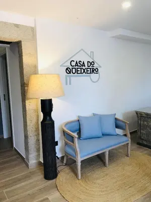 a blue chair and a lamp in a room at CASA DO QUEIXEIRO in Castroverde