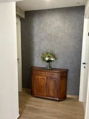 a vase of flowers on a wooden cabinet in a hallway at CASA DO QUEIXEIRO in Castroverde