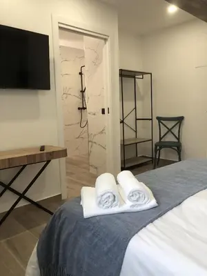 a bedroom with two towels on a bed with a television at CASA DO QUEIXEIRO in Castroverde