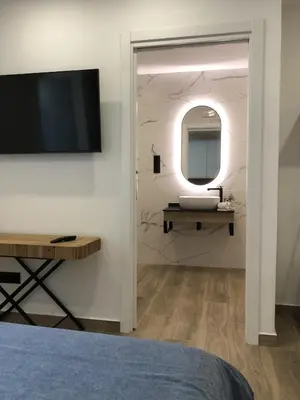 a bedroom with a tv and a mirror on a wall at CASA DO QUEIXEIRO in Castroverde