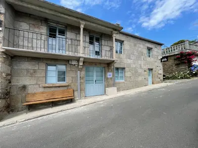 a building with a bench on the side of the street at CASA DO QUEIXEIRO in Castroverde