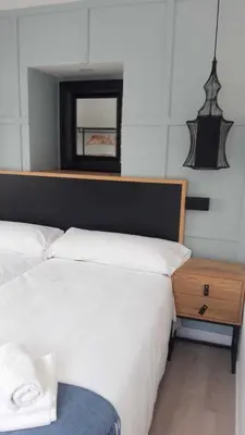 a bedroom with two beds and a mirror on the wall at Apartamento 04 in Castroverde