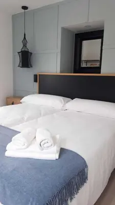 a white bed with two folded towels on it at Apartamento 04 in Castroverde