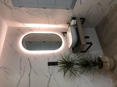 a bathroom with a toilet with a light on the floor at Apartamento 04 in Castroverde