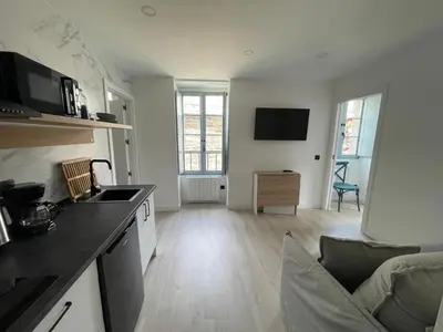 a kitchen with a counter top and a living room at Apartamento 04 in Castroverde