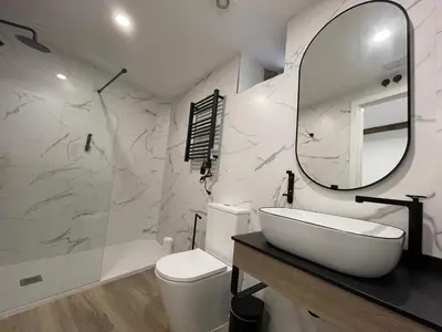 a white bathroom with a sink and a mirror at Apartamento 04 in Castroverde