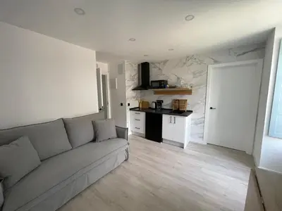 a living room with a couch and a kitchen at Apartamento 04 in Castroverde