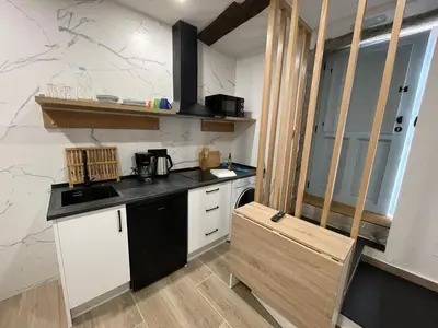a kitchen with white cabinets and a black counter top at Apartamento 04 in Castroverde