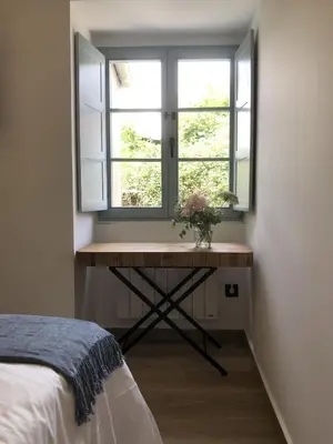 a bedroom with a table in front of a window at Apartamento 04 in Castroverde