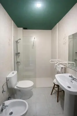 a white bathroom with a toilet and a sink at Coronel Somiedo by Unusual Hotels in El Puerto de Somiedo
