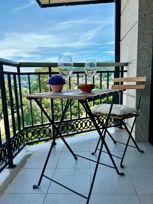 two wine glasses sitting on a table on a balcony at Vistas Miño in Ourense