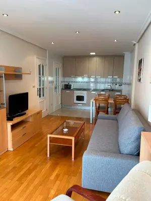 a living room with a couch and a table and a kitchen at Vistas Miño in Ourense