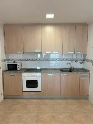 a kitchen with wooden cabinets and a white stove top oven at Vistas Miño in Ourense