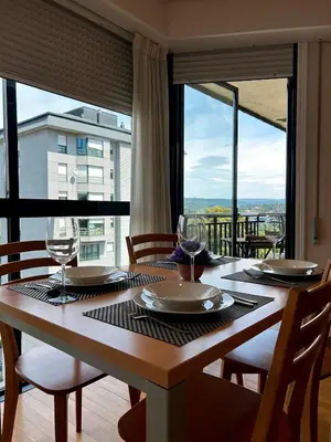 a table with wine glasses and a view of a balcony at Vistas Miño in Ourense