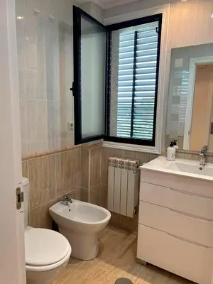 a bathroom with a white toilet and a sink at Vistas Miño in Ourense