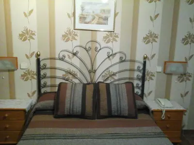 a bedroom with a bed with a black head board at Hostal Piñera in Vega de Espinareda