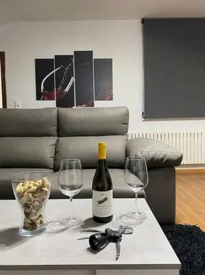 a bottle of wine and two wine glasses on a table at Añada17 in Monforte de Lemos