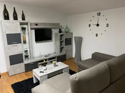 a living room with a couch and a clock on the wall at Añada17 in Monforte de Lemos