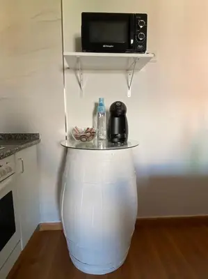 a table in a kitchen with a microwave on a wall at Añada17 in Monforte de Lemos
