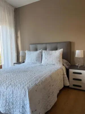 a bedroom with a bed with two night stands and two lamps at Airiños Aires in Santiago de Compostela
