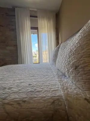 a bedroom with a large bed with a window at Airiños Aires in Santiago de Compostela