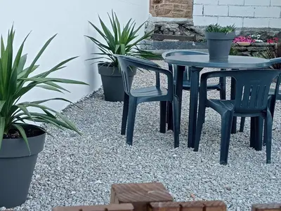 a table and chairs on a gravel patio with plants at Casa Tome A Teixeira - Ribeira Sacra in Teixeira