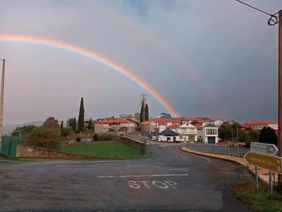 a rainbow in the sky over a town at Casa Tome A Teixeira - Ribeira Sacra in Teixeira